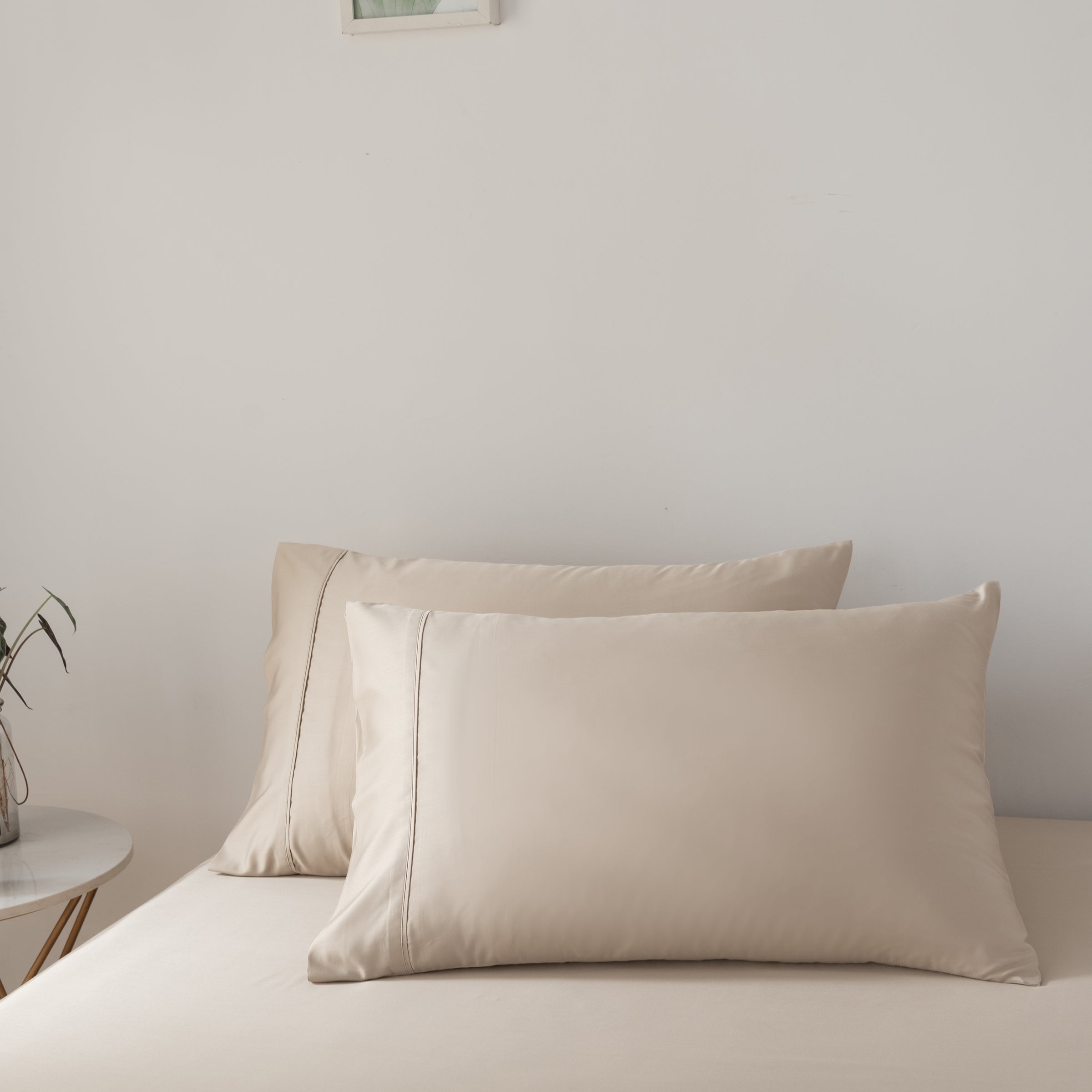 Beige bamboo pillows on a bed against a plain wall