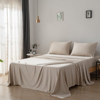 Beige bamboo sheets and pillows on a bed in a bedroom with light decor.
