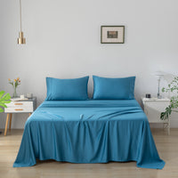 Blue bamboo sheet set on a bed in a bedroom with white walls and minimal decor.