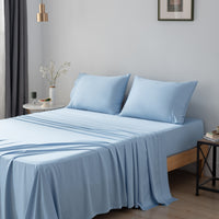 Blue bamboo bed sheets and pillows on a bed in a bedroom setting.