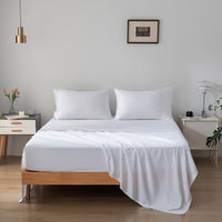 Bedroom with a wooden bed frame and white bamboo bedding
