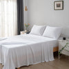 Bedroom with a neatly made bed featuring white bamboo bedding and pillows.