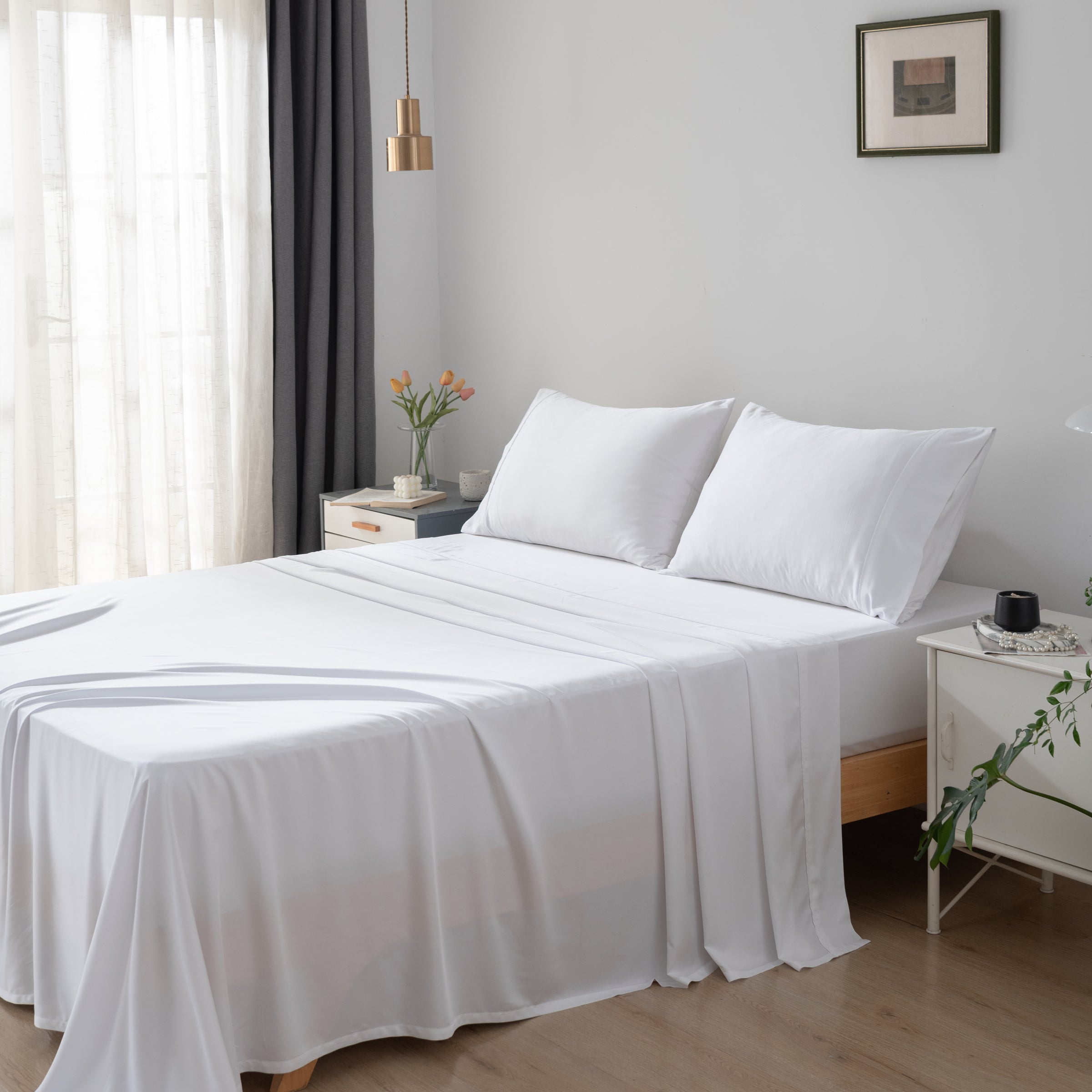 Bedroom with a neatly made bed featuring white bamboo bedding and pillows.